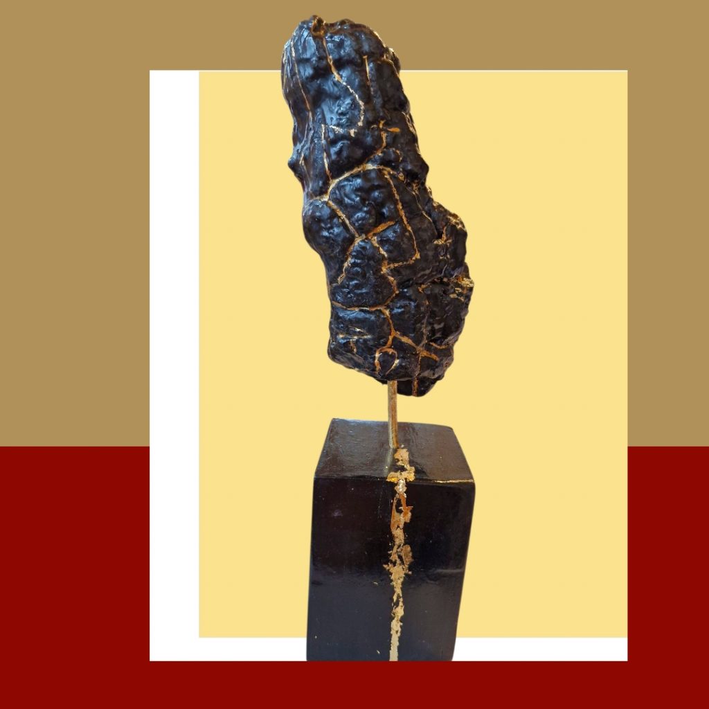 eine kräftige in schwarz angemalte Rinde und in den Rindenvertiefungen fließt Gold.